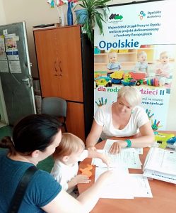 Dwie kobiety i dziecko siedzące przy stole w biurze projektu